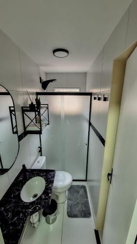 a bathroom with a white toilet and a sink at Mar e Aconchego próx ao Beach Parck e FioCruz in Eusébio