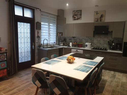 une cuisine avec une table avec un bol de fruits dessus dans l'établissement Une petite campagne en ville, au Mans