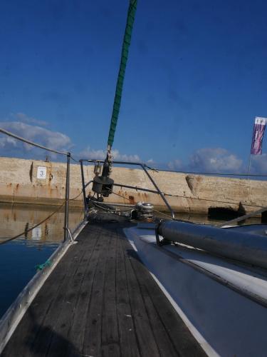 a wooden dock with a boat in the water at Nanoshka Yacht in Tel Aviv