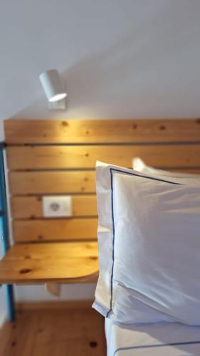 a bed with a wooden headboard and a night stand at Tonea's Houses in Himare