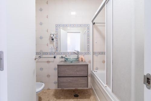 a bathroom with a sink and a mirror at Sea Breeze in Portimão