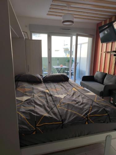 - une chambre avec un lit doté d'une couette en noir et or dans l'établissement Studio calme et paisible, climatisé avec terrasse au dernier étage, 100m du tramway et 20 min de la promenade des anglais, à Nice