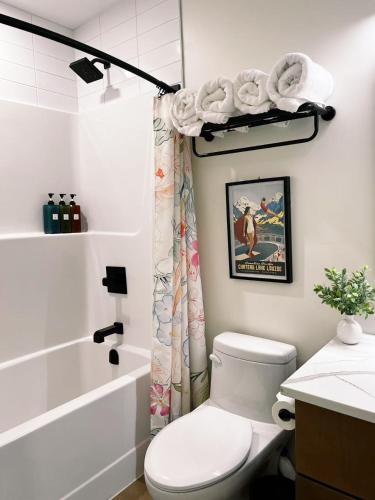 a white bathroom with a toilet and a shower at Raven's Peak 105 - Ultra luxe Mountain Retreat in Canmore
