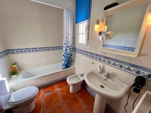 ein Badezimmer mit Toilette, Waschbecken und Badewanne in der Unterkunft Casa Verdemar Golf Islantilla in Islantilla