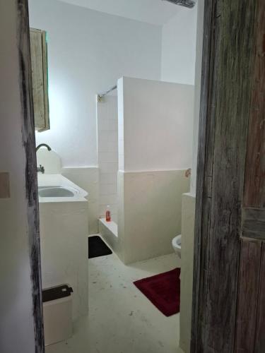 a white bathroom with a sink and a toilet at Villa Dolphin in Mtwapa