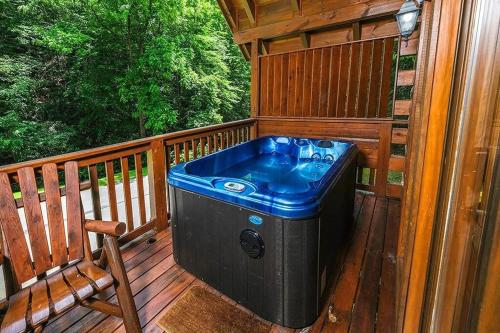 a hot tub sitting on a deck on a porch at Yeti Lodge by Avada Properties in Gatlinburg