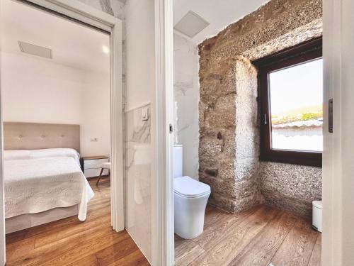 Santa MaríaAlbergue Turistico En Armenteira A Fragua do Ferreiro的一间卧室配有一张床,浴室设有窗户