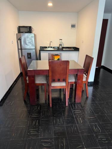 a kitchen with a table and chairs and a refrigerator at Vallclaire Suites in Barranquilla