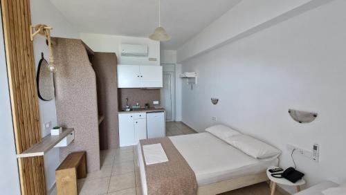 a small room with a bed and a kitchen at Edelweiss Rent Rooms-Rent a Car in Tsoútsouros