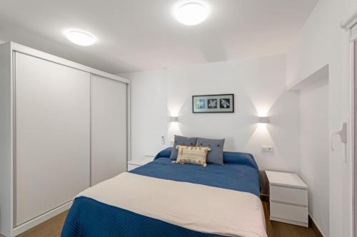 Un dormitorio con una cama y una pared blanca. en ENEXO BEACH HOUSE, en San Bartolomé