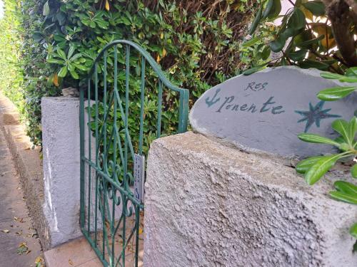 a gate with writing on it next to a rock at Residenza Ponente in Stintino