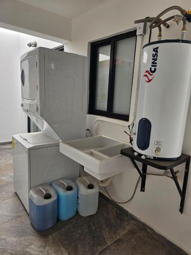 a kitchen with a sink and a washing machine at Casa Abejas in Culiacán