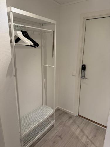 a walk in closet with white walls and a door at Stor attraktiv studioleilighet i sentrum in Trondheim