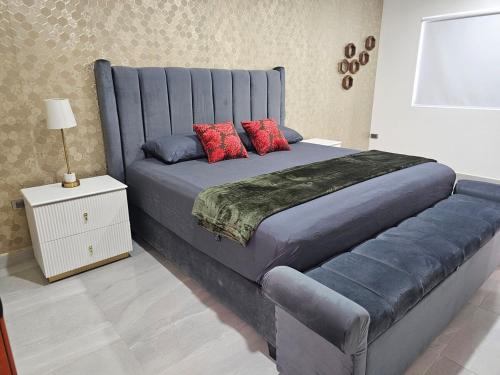 a bedroom with a large blue bed with red pillows at Casa Abejas in Culiacán