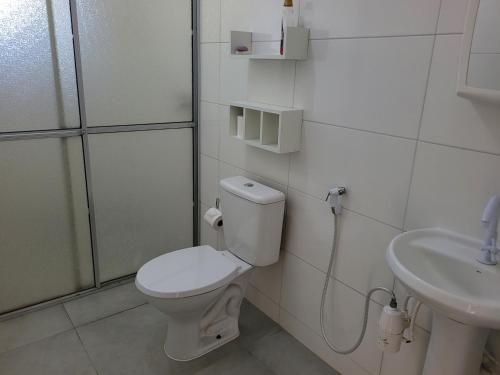 a bathroom with a toilet and a sink at Cantinho da nona Nova Trento SC in Nova Trento