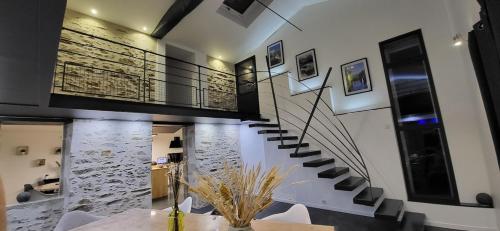 una escalera en una casa con un muro de piedra en Gite le Parveau, 3 étoiles meublé de tourisme, en La Guiltière