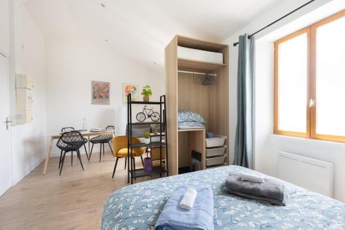 une chambre avec un lit, un bureau et une table dans l'établissement L'Isle en Blanc - 4 couchages - Hypercentre - Clim - Wifi, à LʼIsle-sur-la-Sorgue