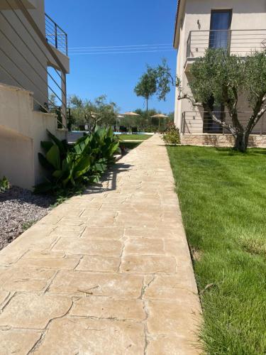 a stone walkway in front of a house at Three Charites Resort in Gialova