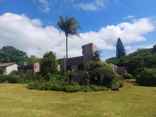 a house with a palm tree in a yard at Daven Guest House in Pietermaritzburg