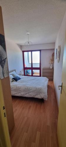 une chambre avec un lit et une grande fenêtre dans l'établissement Vue magnifique sur l'océan et les dunes !, à Saint-Hilaire-de-Riez