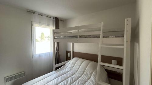 une chambre avec deux lits superposés et une fenêtre dans l'établissement Appartement 2 pièces - Gruissan GN190-015, à Gruissan