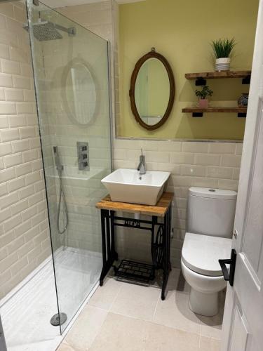 a bathroom with a sink and a shower and a toilet at Cosy Wee Cottage in Monkton