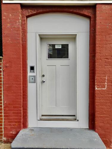 a white door in a red brick building at Penn Station Room Motel Casa in Newark