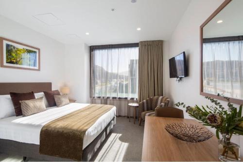 a hotel room with a bed and a table at Wyndham Garden Remarkables Park Queenstown in Queenstown