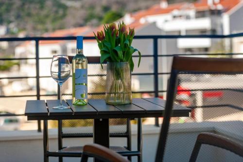 a table with a bottle of wine and a glass at Mokos Modern Suite with Sea View and Jacuzzi in Dubrovnik