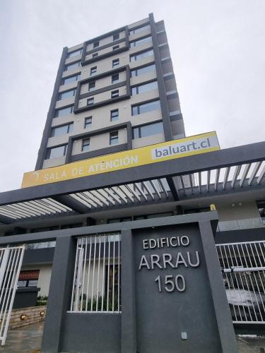 a tall building with a sign in front of it at Departamento moderno y central en Chillan in Chillán