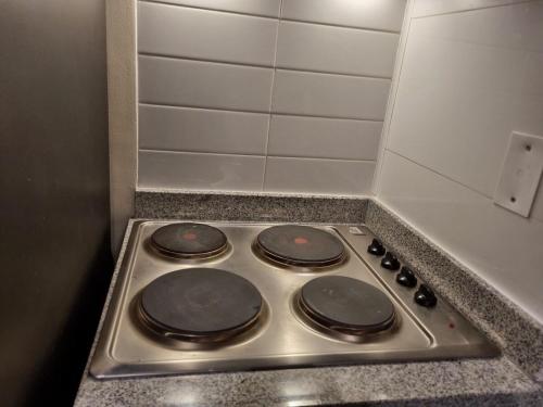 a stove top with four burners in a kitchen at Departamento moderno y central en Chillan in Chillán
