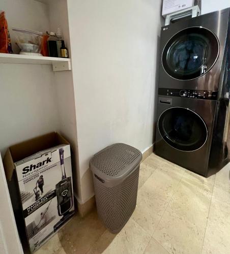 a laundry room with a washing machine and a trash can at Apto Yoo Vista al Mar in Panama City