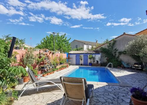 une piscine dans une cour avec des chaises et une maison dans l'établissement Villa with pool near sea and garrigue, à Cournonterral