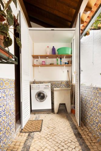 a washer and dryer in a garage with a door open at Casa Benny Countryside Guesthouse CENTER PORTUGAL in Hombres