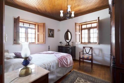 a bedroom with a bed and a table and windows at Casa Benny Countryside Guesthouse CENTER PORTUGAL in Hombres