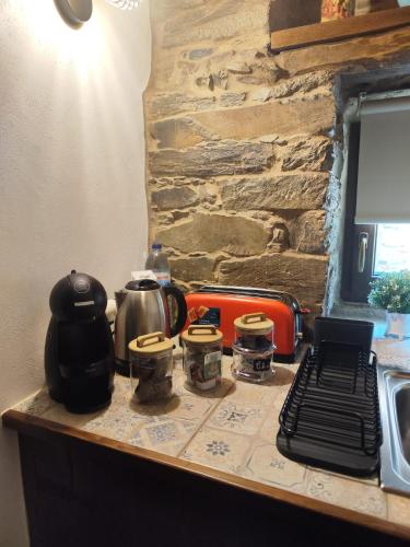 a kitchen counter with a stove and a stone wall at Casa do Tear in Sobreira Formosa