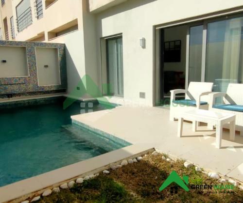 a house with a swimming pool with a table and chairs at Green Hôte in Gammarth