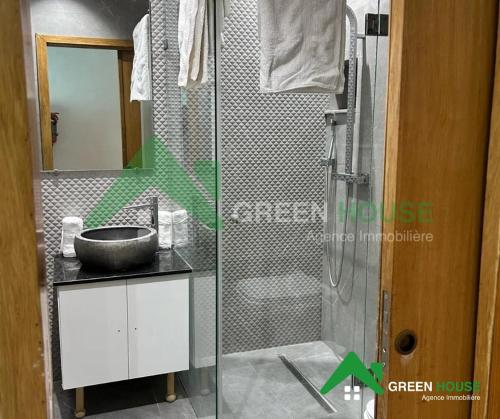 a bathroom with a glass shower with a sink at Green Hôte in Gammarth