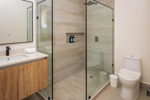 Cumbres Garden luxury apartments في كانكون: حمام مزود بمرحاض ودش زجاجي