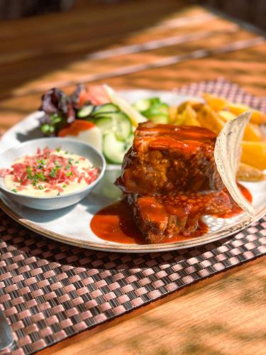 a plate of food with meat and vegetables on a table at La Quinta by Wyndham Quito in Quito