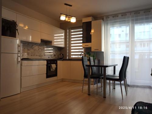 a kitchen with a table and chairs in a room at Apartament AQUAPARK in Reda