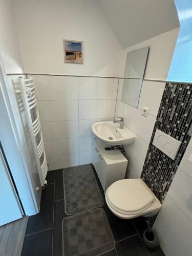 a small bathroom with a toilet and a sink at Moderne Ferienwohnung in toller Lage in Berghausen