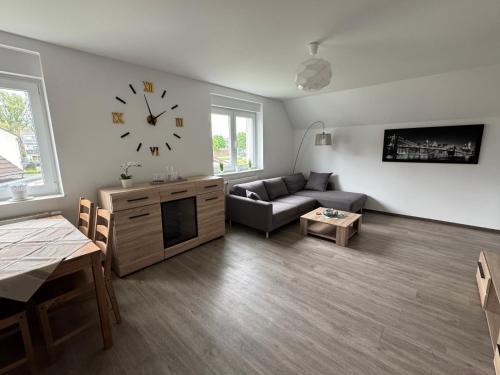 a living room with a couch and a clock on the wall at Moderne Ferienwohnung in toller Lage in Berghausen