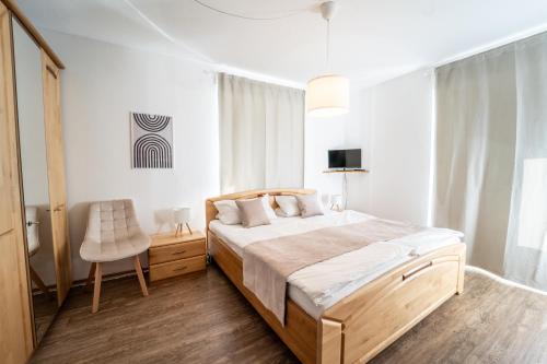 a bedroom with a large bed and a chair at Gästehaus Mack in Trittenheim