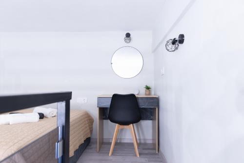 a bedroom with a desk and a black chair at Paradise Lofts in Asprovalta