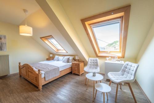 a bedroom with a bed and a table and chairs at Gästehaus Mack in Trittenheim