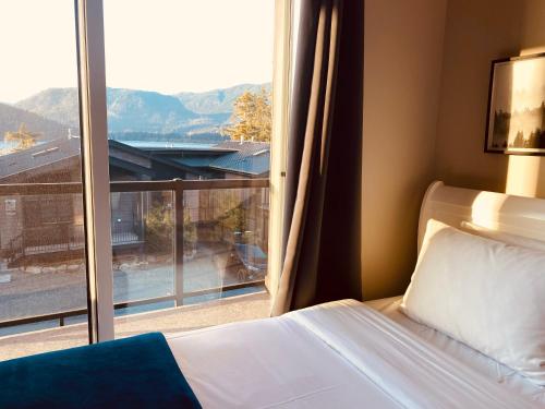 a bedroom with a bed and a large window at Haven On The Hill in Port Renfrew