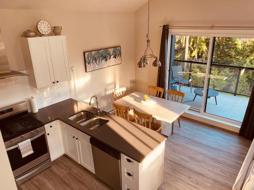 a kitchen and dining room with a view of a table at Haven On The Hill in Port Renfrew