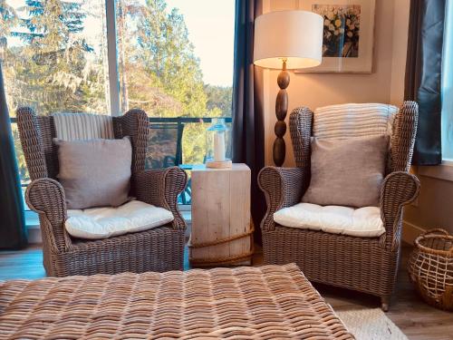 two chairs and a table in a living room at Haven On The Hill in Port Renfrew