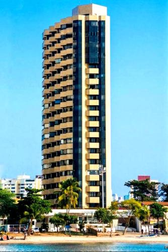 a tall building on the beach next to the water at 756 Golden Flat Fortaleza Frente Mar in Fortaleza